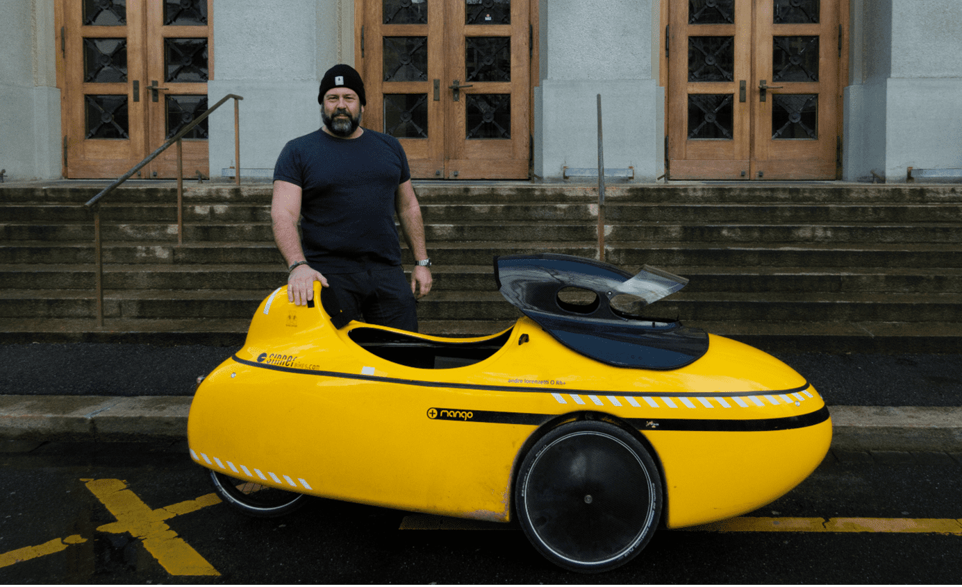 Titelbild 1: André Lorenzetti mit seinem Liegevelo vor einem Eingang des Gymnasiums Kirchenfeld; Foto: Melinda Widler